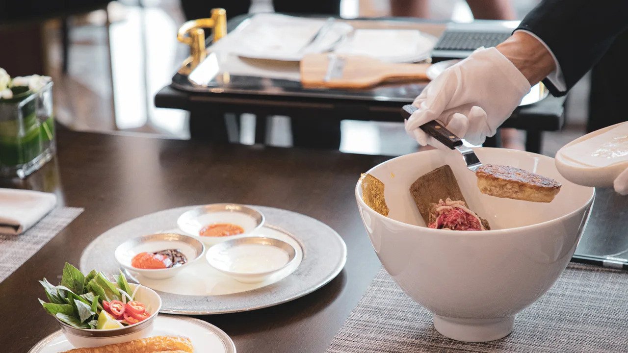 Mẹo thưởng thức: Đừng vội cho thêm tương ớt hay dấm tỏi ngay. Hãy nếm thử muỗng nước dùng đầu tiên ngay sau khi lửa tắt để cảm nhận rõ rệt hương rượu Gin quyện trong vị ngọt của xương bò.